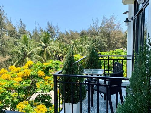 会安Santa Sea Villa的阳台配有桌椅和鲜花。