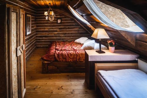 斯塔勒斯普拉维Penzion Sklípek的小木屋内一间卧室,配有两张床