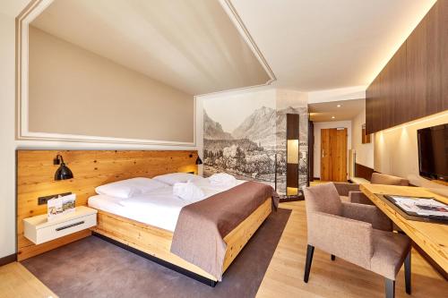 格赖瑙艾姆班德喜酒店的酒店客房,配有一张床、一张桌子和椅子