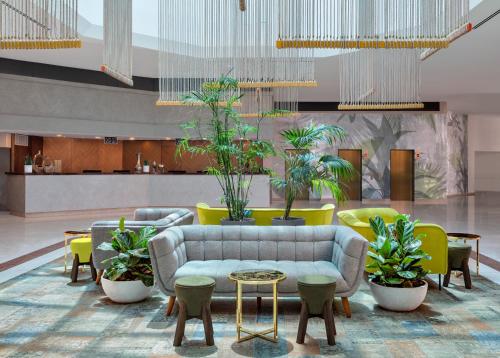 埃拉特Vert Hotel Eilat by AFI Hotels的大堂配有沙发、桌子和盆栽植物