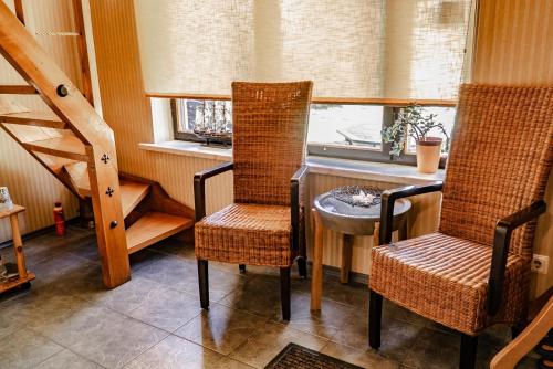 里加萨姆皮特拉玛雅宾馆的一间设有两把椅子、一张桌子和一个窗户的房间