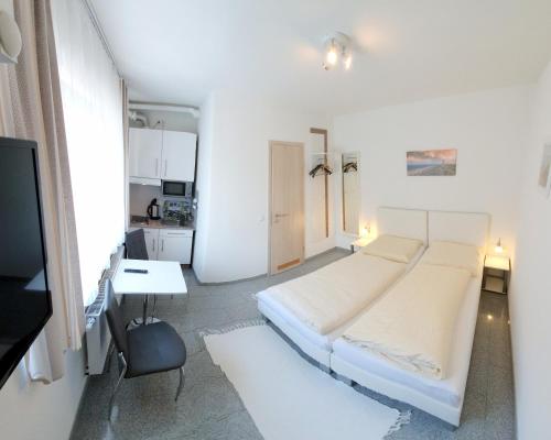 法伊茨赫夏伊姆古堡公园之家民宿的白色卧室配有床和书桌