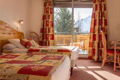 莱德萨阿尔卑斯Hotel Adret的酒店客房设有两张床和窗户。