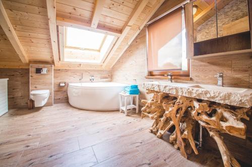 加尔米施-帕滕基兴Downtown Suite Alpi的浴室配有大型白色浴缸和水槽