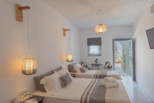 帕拉斯波罗斯弗莱戈利斯村庄酒店的白色客房的两张床,配有两盏灯