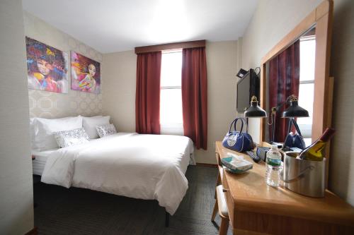 纽约蔤蒙莎酒店的酒店客房设有一张床、一张书桌和窗户。