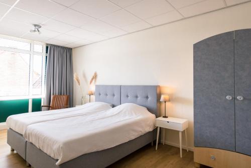 霍勒姆Hotel-Brasserie De Walvisvaarder的一间卧室设有一张大床和一个窗户。
