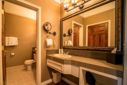本德松树岭酒店的一间带水槽、镜子和卫生间的浴室