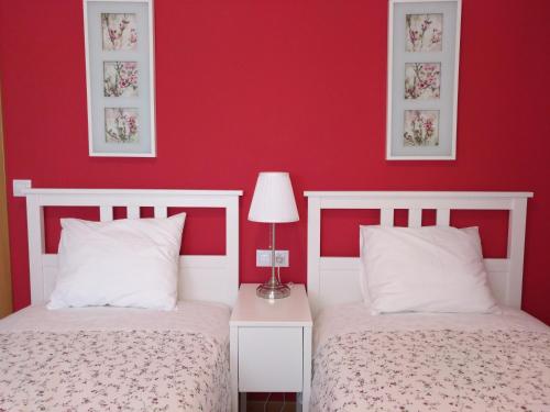 阿尔格达斯Apartamento Turistico Cigüeña de Arguedas的卧室设有两张床铺和红色的墙壁