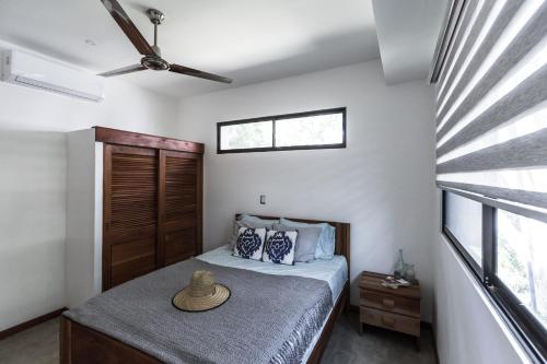 里瓦斯Eco Casita Phase I #10的一间卧室,配有一张床,上面有帽子