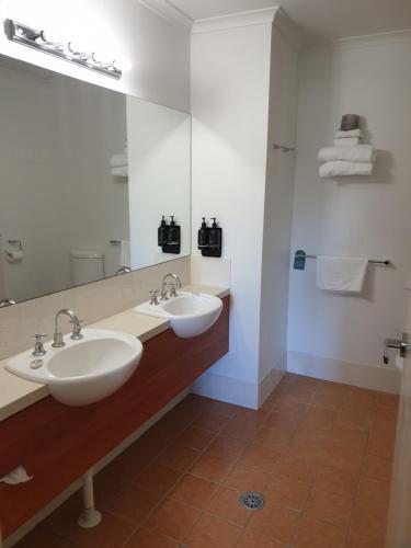 堪培拉Ramada Encore Belconnen的一间带两个盥洗盆和大镜子的浴室