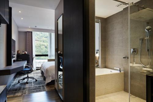 台北天阁酒店台北士林的酒店客房设有一间卧室、一个浴缸和一张床
