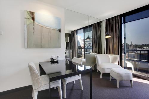 霍索恩区Corporate Living Accommodation Hawthorn的客厅配有桌子和白色椅子