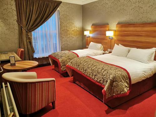 斯莱戈Sligo Southern Hotel & Leisure Centre的酒店客房设有两张床和窗户。
