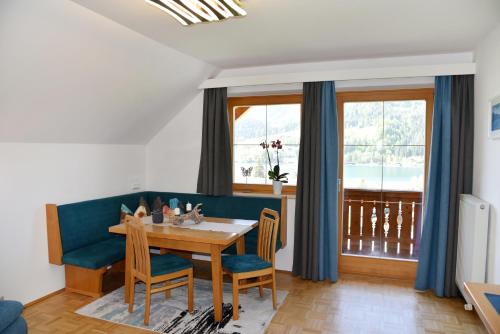 魏森湖Haus Christina的一间配备有蓝色沙发及桌椅的用餐室