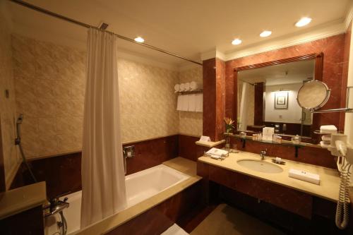 阿格拉捷波宫殿酒店的带浴缸、水槽和镜子的浴室