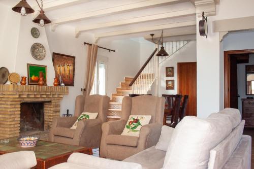 科尼尔-德拉弗龙特拉Villas Dehesa Roche Viejo的客厅配有椅子和壁炉