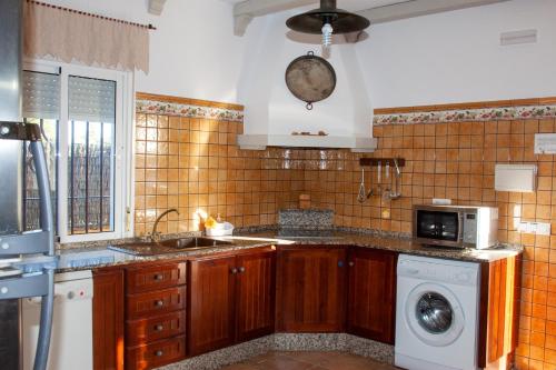 科尼尔-德拉弗龙特拉Villas Dehesa Roche Viejo的厨房配有水槽和洗衣机