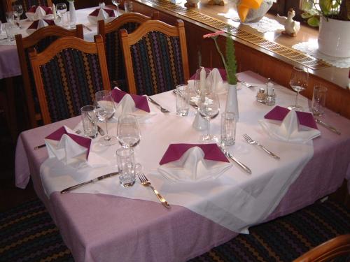 PillHotel Klausen的一张桌子,上面有紫色的桌布,连带餐巾和酒杯
