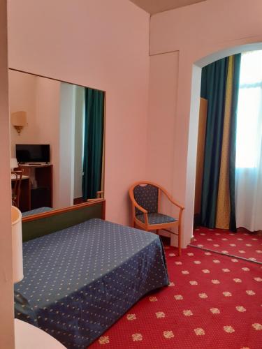 乌斯马泰波罗酒店的配有一张床和一把椅子的酒店客房