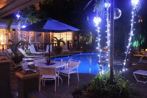 劳德代尔堡珊瑚礁宾馆的一个带桌椅的庭院和一个夜间游泳池