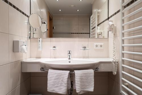 纽科琴格罗斯夫斯托特尔宾馆的浴室配有盥洗盆、镜子和毛巾