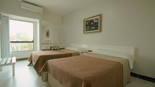 卡宁德圣弗朗西斯科Xingó Parque Hotel的带窗户的客房内的两张床