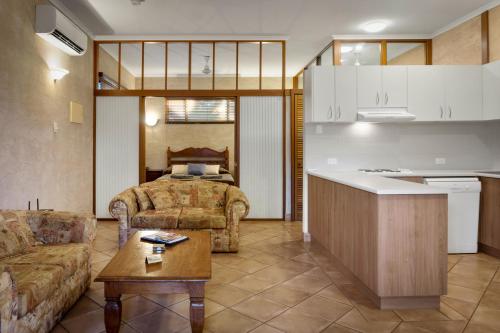 布鲁姆蓝色海洋度假酒店的厨房以及带沙发和桌子的客厅。