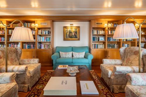 丰沙尔拉戈金塔花园酒店的客厅配有蓝色的沙发和书架