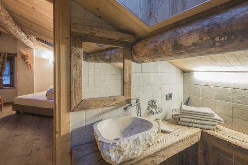 瓦尔迪登特罗Agriturismo Baita De L'ALL的客房内的浴室设有大型石质水槽