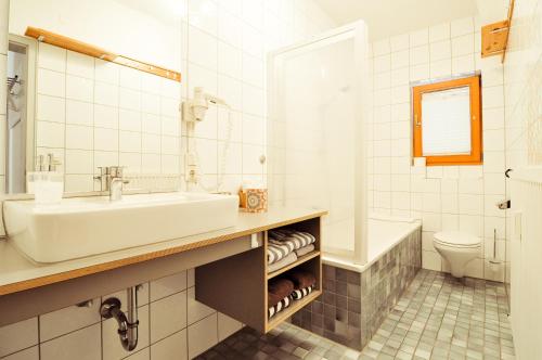 奥巴拉马高Ferienwohnungen Evi Huber的一间带水槽、浴缸和卫生间的浴室