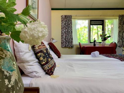 Diepenheim霍尔特餐厅酒店的一间卧室配有两张带白色床单的床