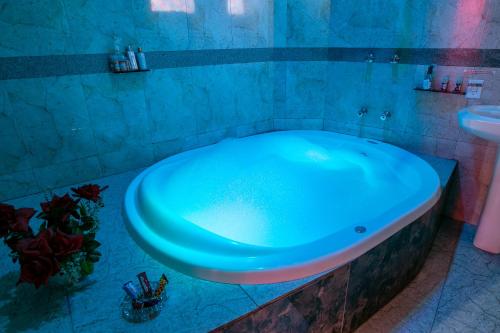 阿雷格里港Motel Desejo的浴室配有蓝色浴缸及水槽