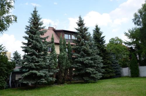 华沙Kwatery Pracownicze TOLEK的前面有树木的房子
