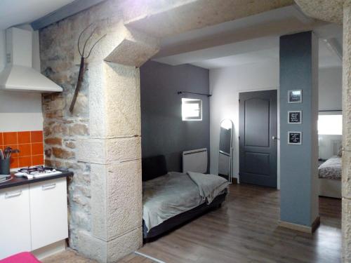 Châtillon-la-PaludLe Gîte du haut的一间设有床铺和石墙的房间