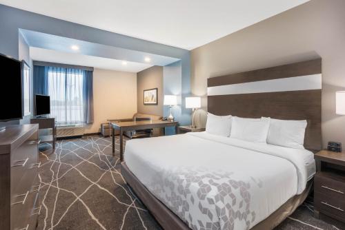 斯普林La Quinta Inn and Suites by Wyndham Houston Spring South的酒店客房设有一张大床和一张书桌。