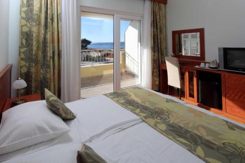 巴什卡沃达多里基尼多沃里酒店的一间卧室设有一张床,享有海景