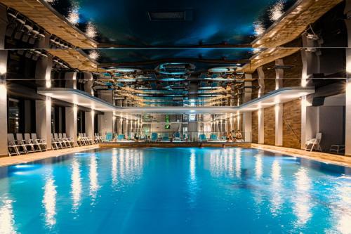 斯维诺乌伊希切Hamilton SPA & Wellness的大楼内一个蓝色的大型游泳池