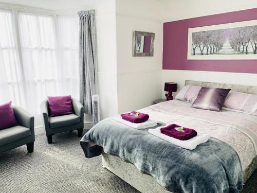 兰戈伦Cambrian House的一间卧室配有一张大床和两把椅子