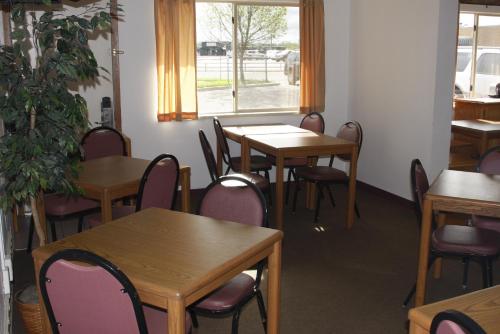 HuronDakota Inn的一间带桌椅的用餐室和窗户。