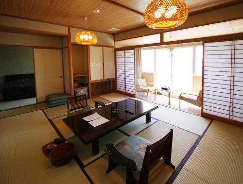 佐渡市湖畔之宿吉田屋酒店的客厅配有木桌和椅子