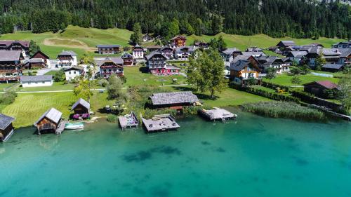 魏森湖See Hotel Kärntnerhof- das Seehotel am Weissensee!的湖泊中央村庄的空中景观