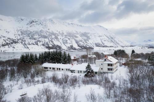 博斯塔德FURU Hostel & Café的山前雪中的房子