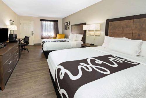 西棕榈滩西棕榈滩 - 佛罗里达收费公路拉金塔酒店的酒店客房设有两张床和电视。