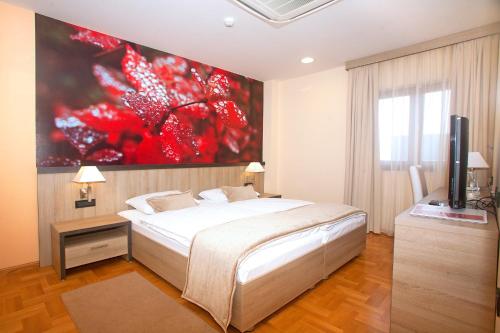 萨格勒布卡利普索酒店 的卧室配有一张床,墙上挂着一幅大画