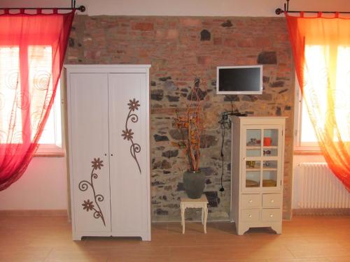 切奇纳谷新堡Monolocale Borgo Antico的一间设有白色橱柜和砖墙的房间