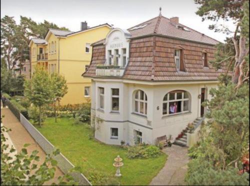 塞巴特阿尔贝克Villa Harmonie的一间白色的大房子,有棕色的屋顶