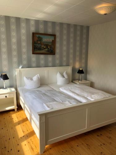 普赖斯特Sleep & Coffee Apartments的一张大白色的床,位于带两张桌子的房间