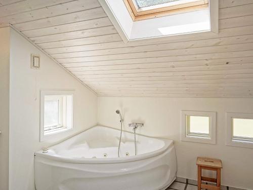 斯皮兹嘉德Four-Bedroom Holiday home in Nexø 14的浴室配有白色浴缸,设有天窗