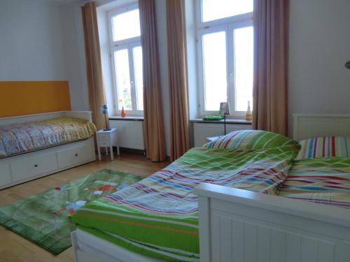 奥斯赛拜-屈隆斯博恩Ferienwohnung Ostseeglück in der Villa Marie的一间小卧室,配有两张床和两个窗户